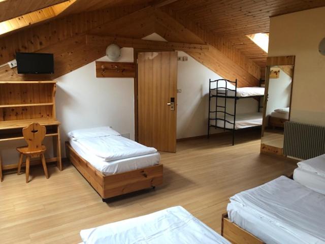 pokój z dwoma łóżkami i biurkiem z komputerem w obiekcie Park Hotel Miramonti w mieście Folgaria