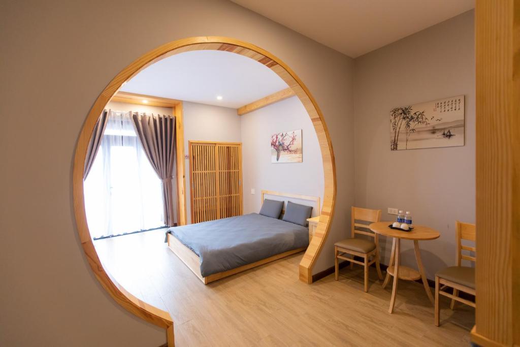 um quarto com uma cama e um espelho redondo em Nguyễn Tài Hostel & Coffee Đà Lạt em Da Lat