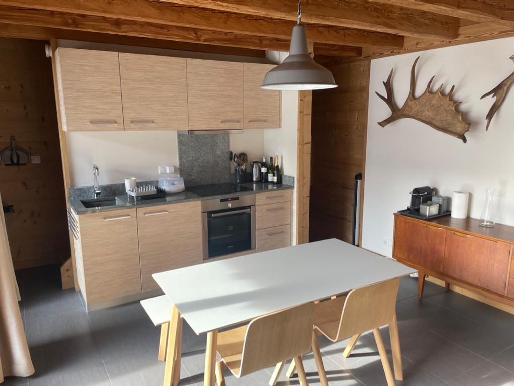 une cuisine avec une table blanche et des armoires en bois dans l'établissement Chalet Moose, à Morzine