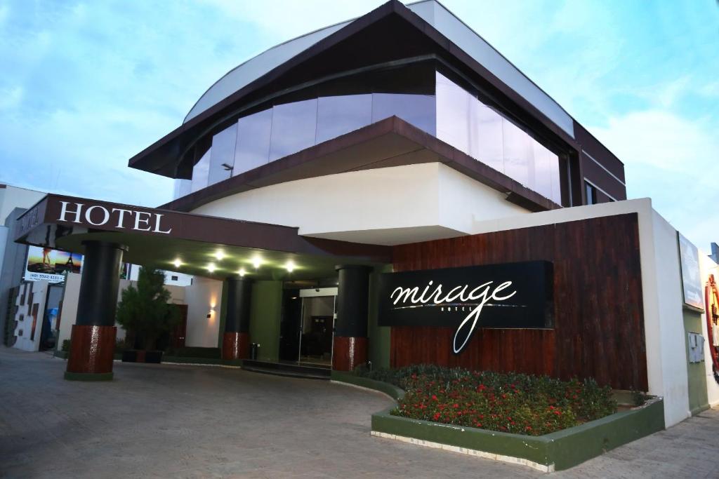 a hotel with a sign in front of a building at Hotel Mirage in Vilhena