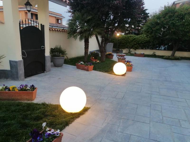 two lights in a courtyard with a house at Lo Chalet in Ponte Galeria