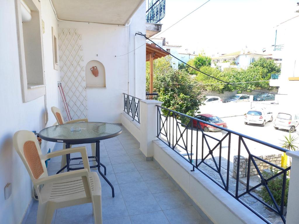 a balcony with a table and chairs and a view of a street at Apartment Kasperakos in Skiathos Town