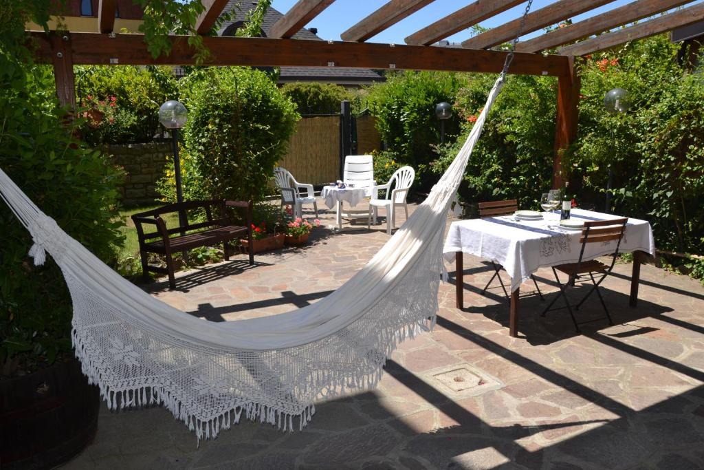 una hamaca en un jardín con mesa y sillas en The Flowers' House, en Potenza