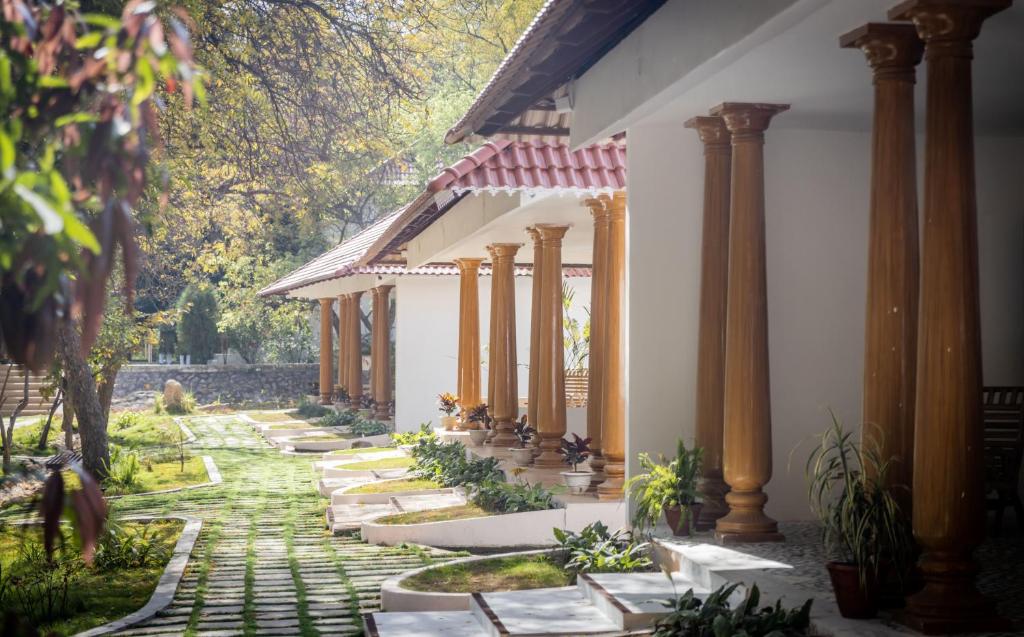 a courtyard with columns and plants in a building at Shatam Jeeva - Ayurveda Wellness Retreat, Jhansi in Jhānsi