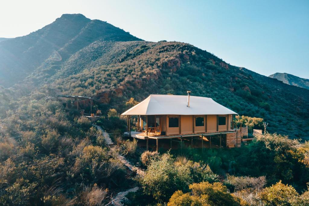 a house on a hill with a mountain in the background at Wolwehoek Private Reserve in Montagu