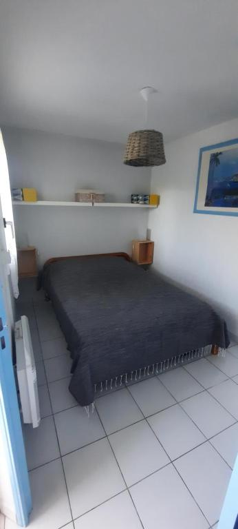 een slaapkamer met een bed op een witte vloer bij SaintCyp in Saint-Cyprien
