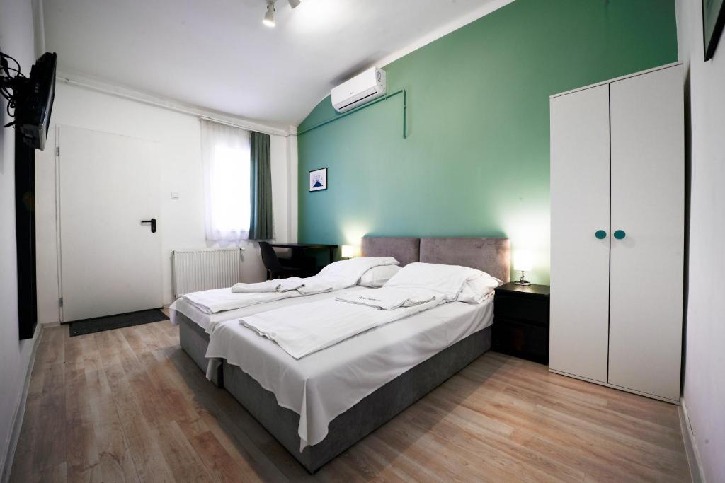 a bedroom with a large bed and a green wall at Chesscom Guesthouse in Budapest