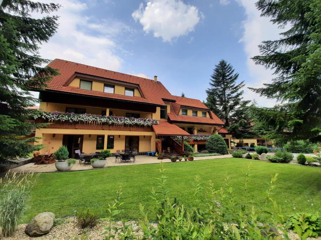 a house with a green lawn in front of it at Apartmány PACIFIC in Belá