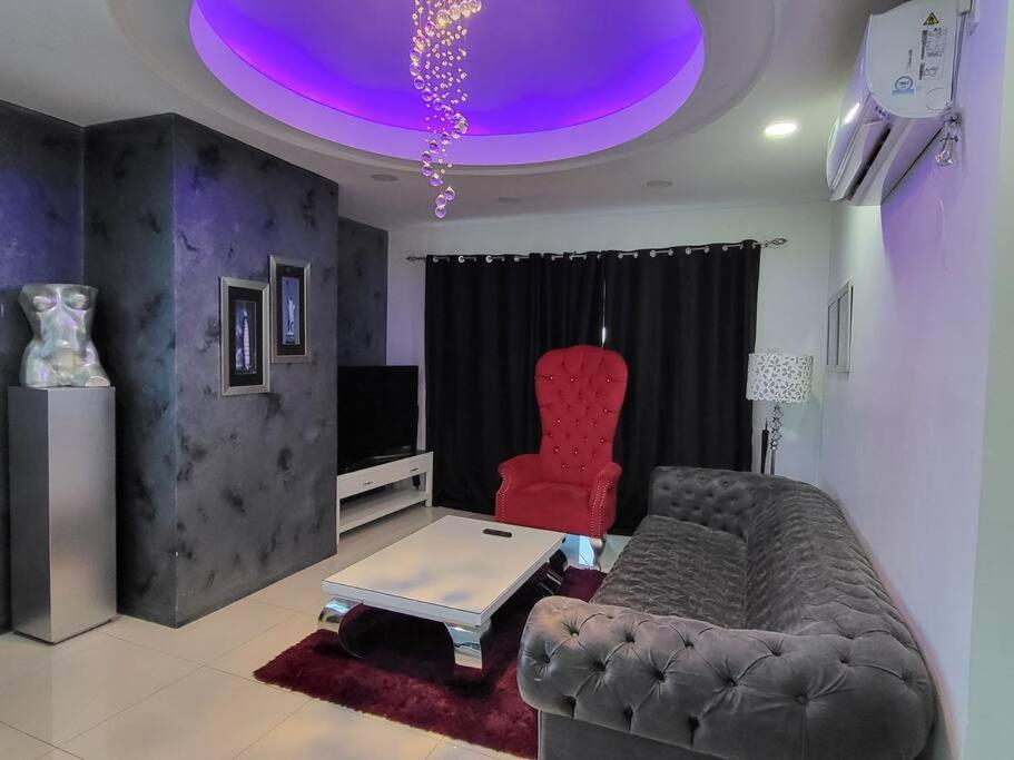 sala de estar con sofá y silla roja en Spacious 2 bedroom. Home comfort + hotel amenities, en Ángeles