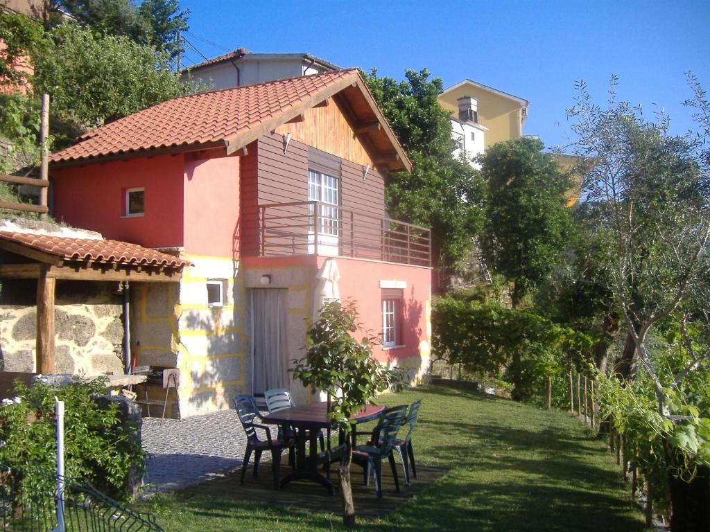 a house with a table and chairs in the yard at Chalé da Fonte - T2 in Geres
