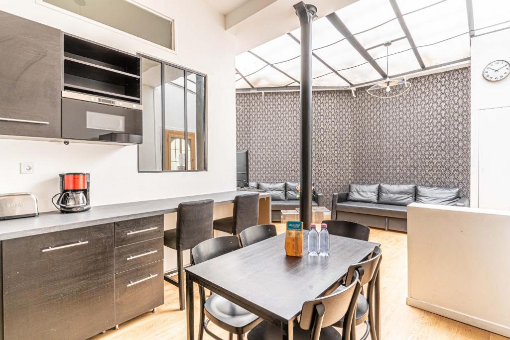 eine Küche und ein Esszimmer mit einem Tisch und Stühlen in der Unterkunft 08 Design Flat Republique in Paris