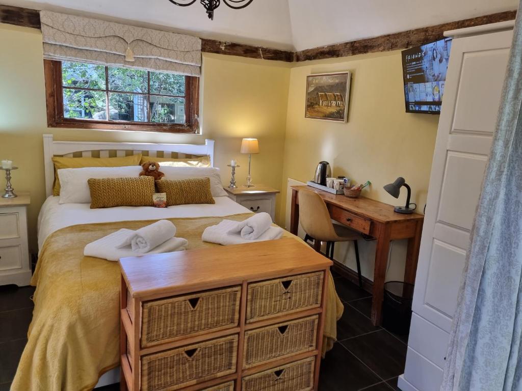 a bedroom with a bed with a desk and a desk at Schuilhoek Garden Terraces in Cape Town