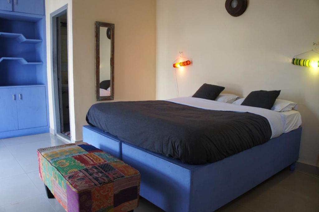 1 dormitorio con 1 cama grande con marco azul en Bed & Chai Guesthouse, en Nueva Delhi