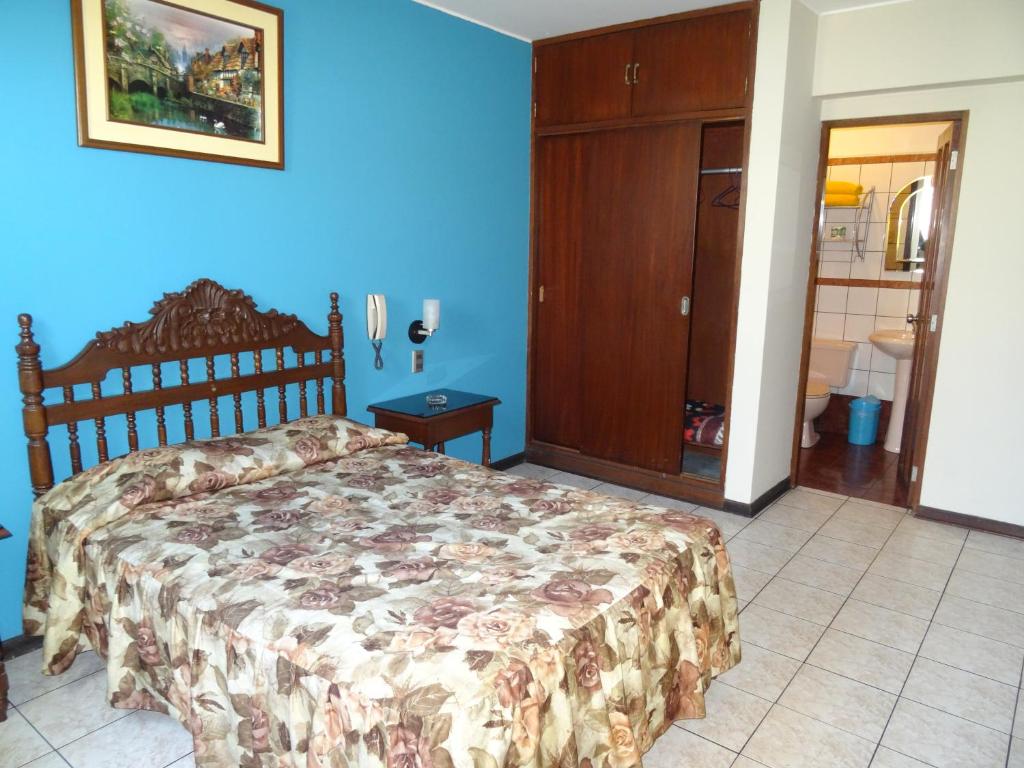 una camera con letto e parete blu di Hotel Nova a Lima