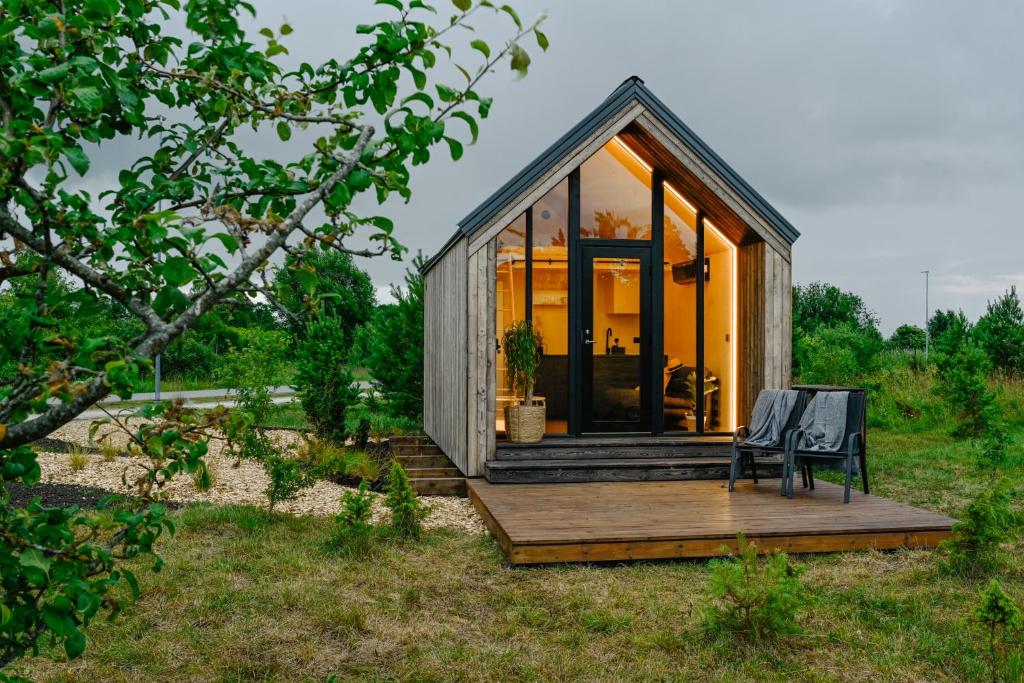 ein winziges Haus auf einer Terrasse mit einer Bank in der Unterkunft Unique Tiny House at Saaremaa Golf & Country Club in Kuressaare