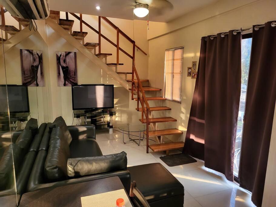 salon z kanapą i telewizorem w obiekcie Resort-type, spacious 1 bedroom condo in Kandi. w mieście Angeles