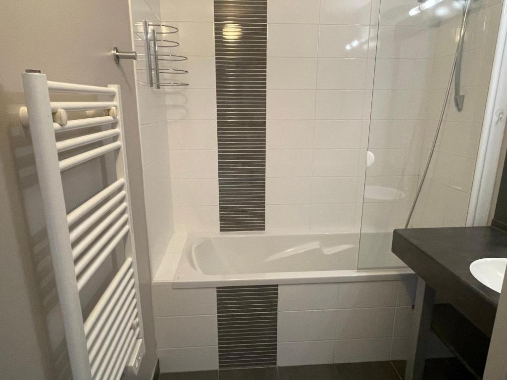 ein Badezimmer mit einer Badewanne und einem Waschbecken in der Unterkunft Magnifique vue mer - Tout confort in Pléneuf-Val-André