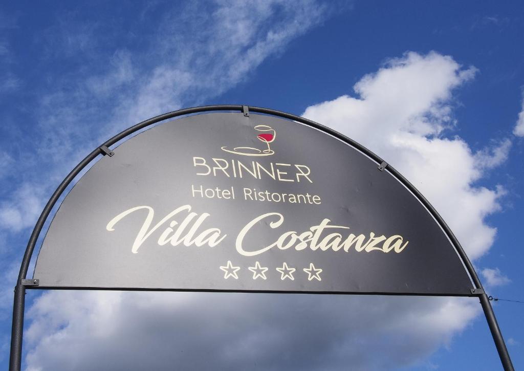 a sign for a hotel restaurant with a blue sky at Hotel Villa Costanza in Pontenure
