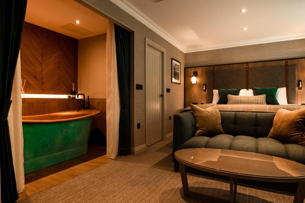 a hotel room with a bed and a couch and a table at Stables Ashbourne in Ashbourne