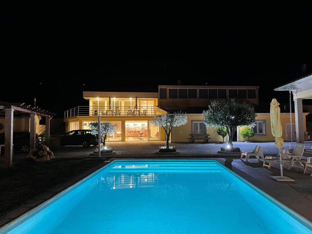 a swimming pool in front of a house at night at Quinta da Menina Guest House in Vila Real