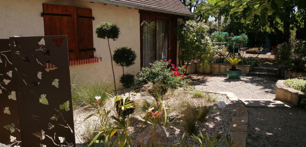 a garden in front of a house with flowers at L'Orme Seul, Maison d'hôtes in Vineuil