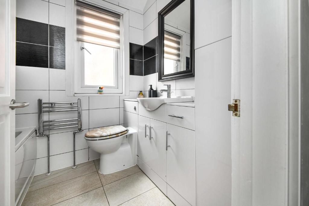 Un baño blanco con inodoro y lavabo. en The White Rose Crown, Free Parking & Wifi, 10beds, en Colchester