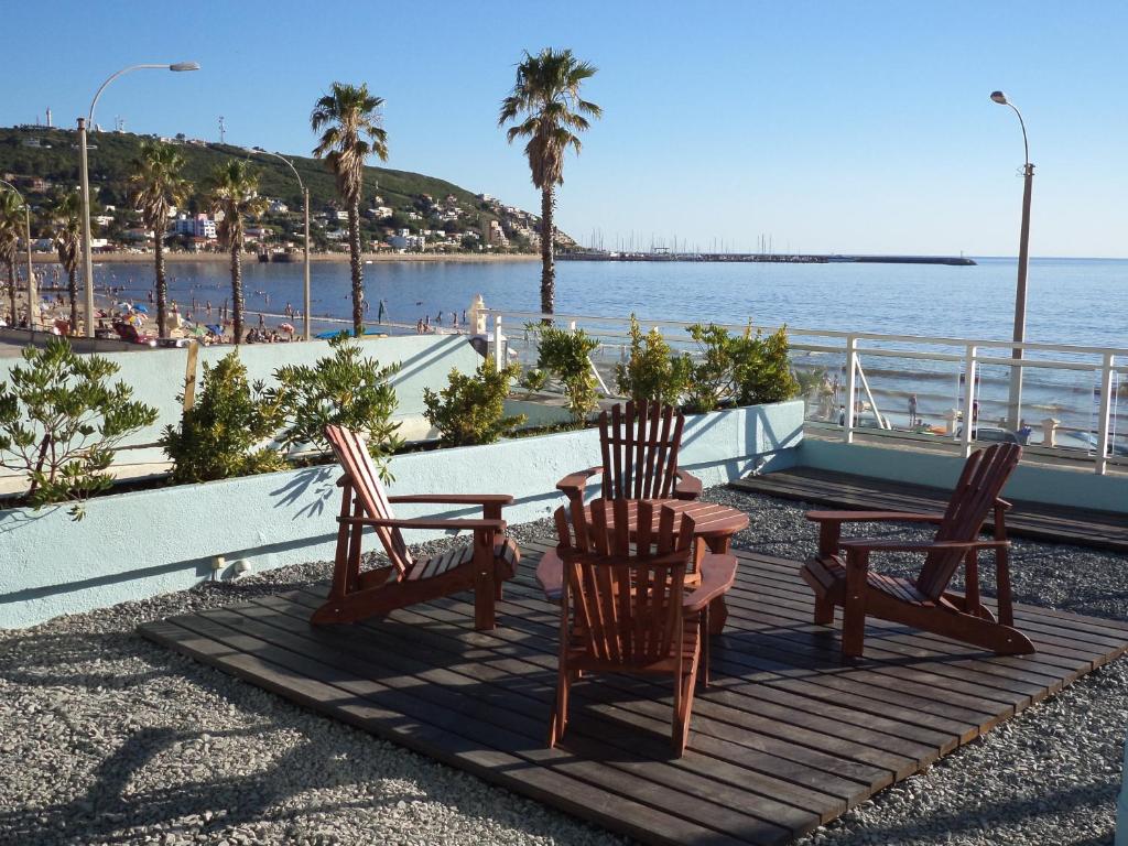 a table and chairs sitting on a deck overlooking the ocean at Hotel Escorial in Piriápolis
