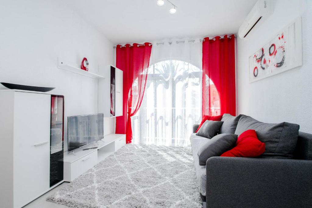 ein Wohnzimmer mit roten Vorhängen und einem Sofa in der Unterkunft Espanatour MADONNA in Torrevieja