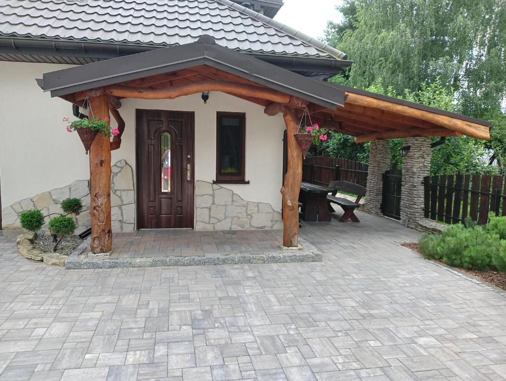 a wooden pergola in front of a house at Zacisze in Rozalin