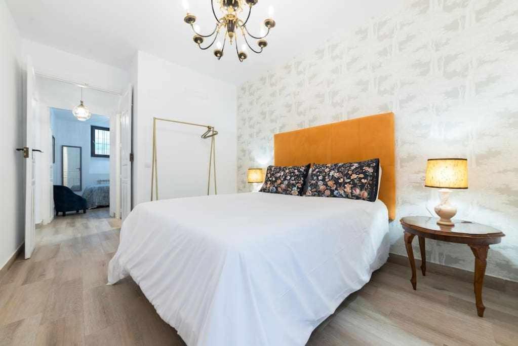 Un dormitorio blanco con una cama grande y una mesa. en Room Boutique Calma Laura By KubiK, en Cáceres