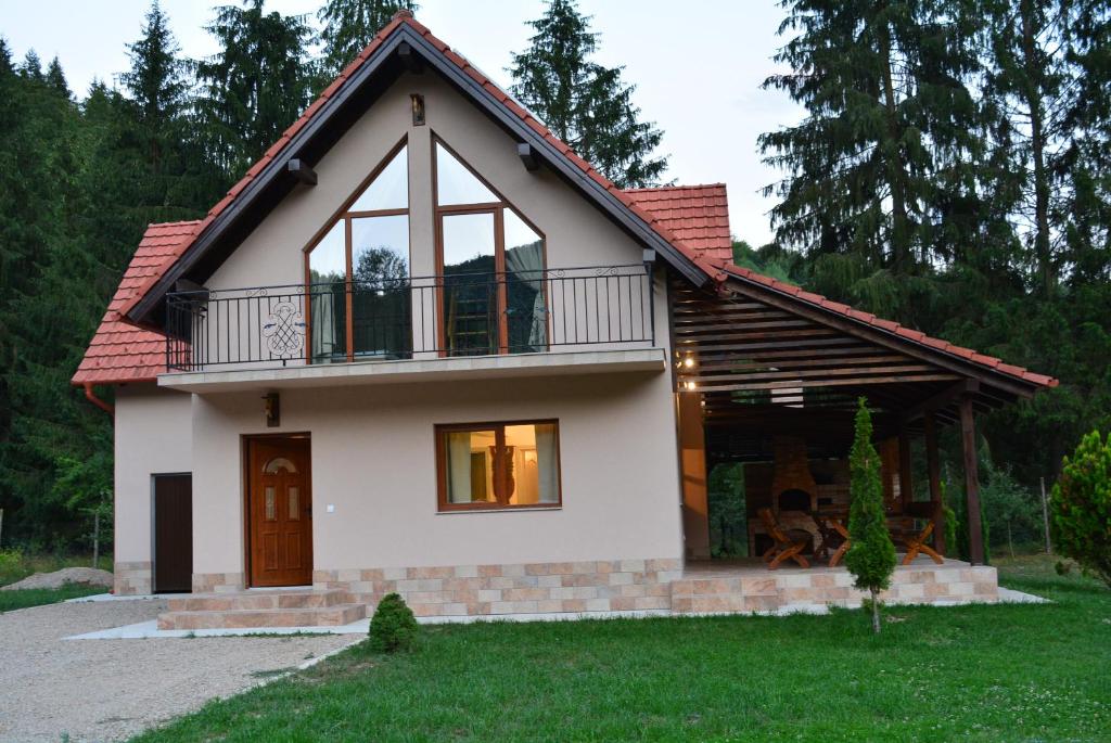 een klein huis met een balkon erboven bij cabana din padure in Finiş