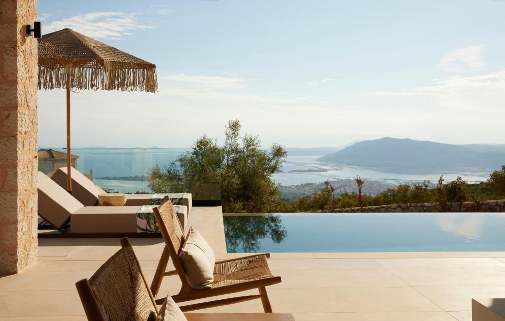 un resort con piscina, sedie e vista di Epiphany Villas Lefkada a Tsoukalades