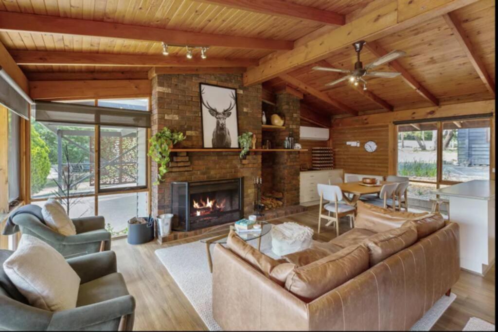 a living room with a couch and a fireplace at AALFOR LODGE - Luxury Cabin with Spa & Cinema! in Mount Buller