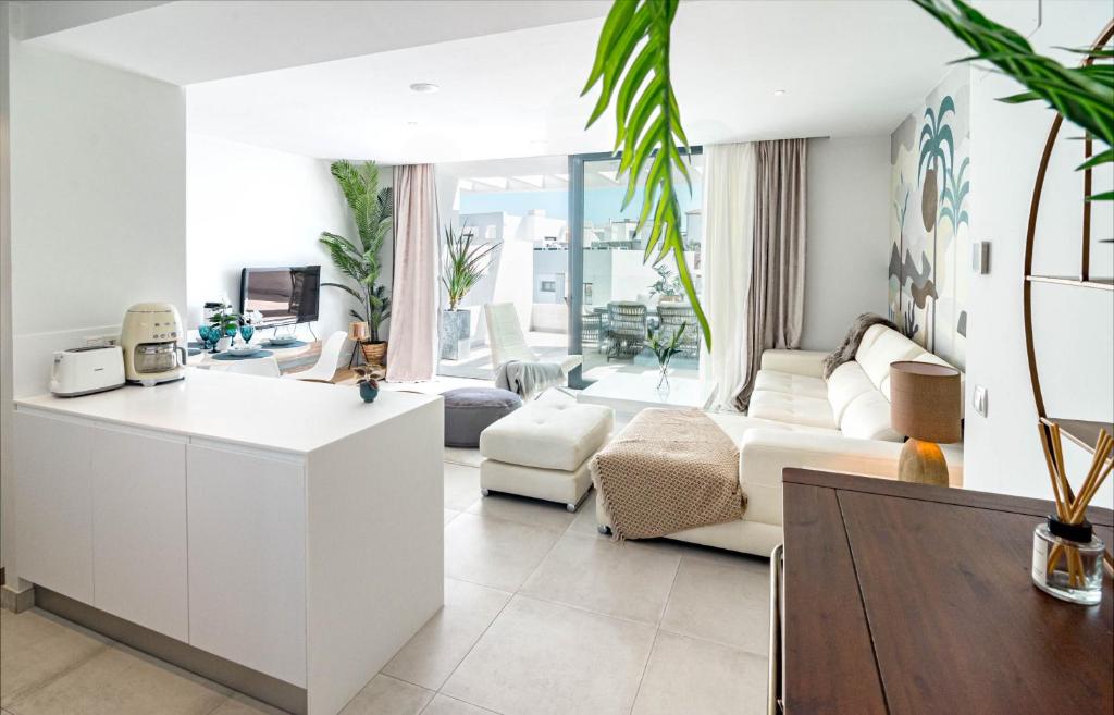 een witte woonkamer met een bank en een tafel bij CDG- Cortijos Del Golf by Roomservices in Estepona