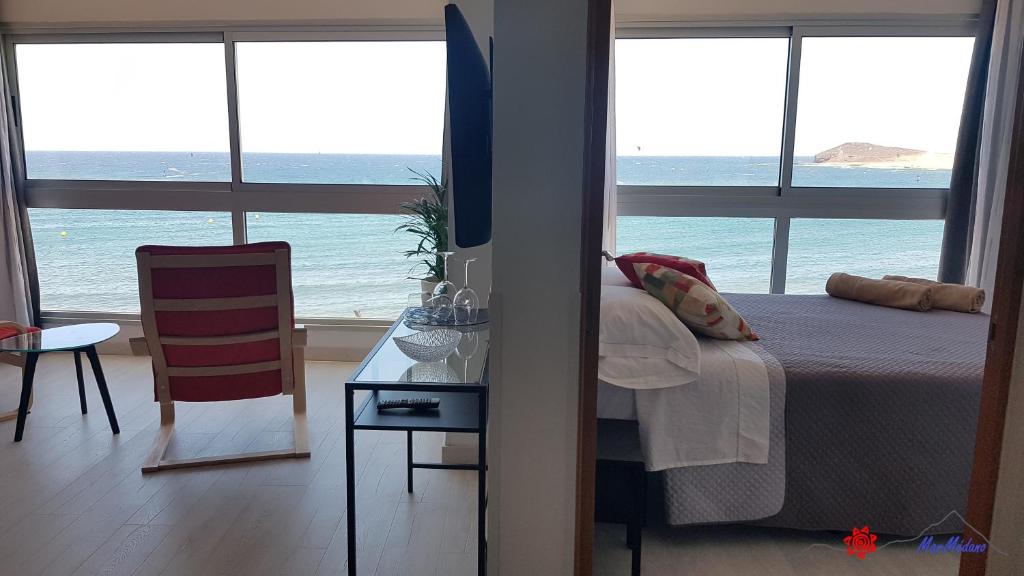 sypialnia z łóżkiem i widokiem na ocean w obiekcie MarMédano Apartamento 3 w mieście El Médano