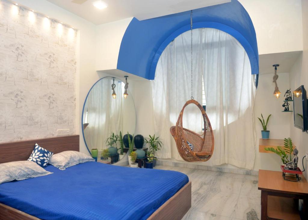 sypialnia z niebieskim łóżkiem i huśtawką w obiekcie Paradise Homestay Civil Lines w mieście Nagpur