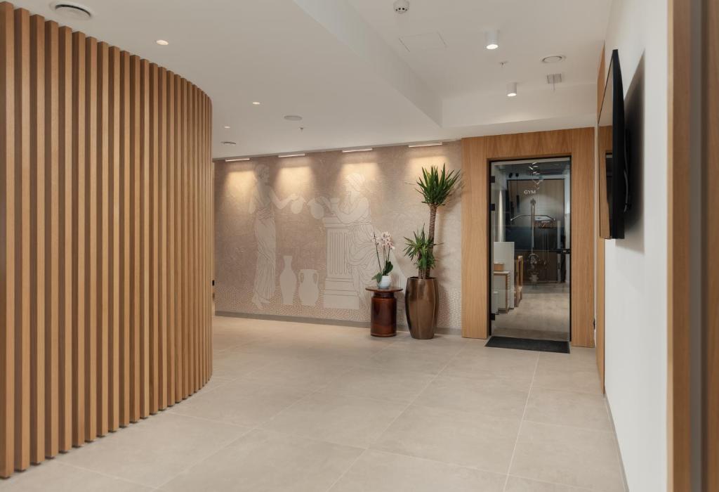 a hallway with wooden walls and a lobby with plants at Dukley Hotel & Resort in Budva