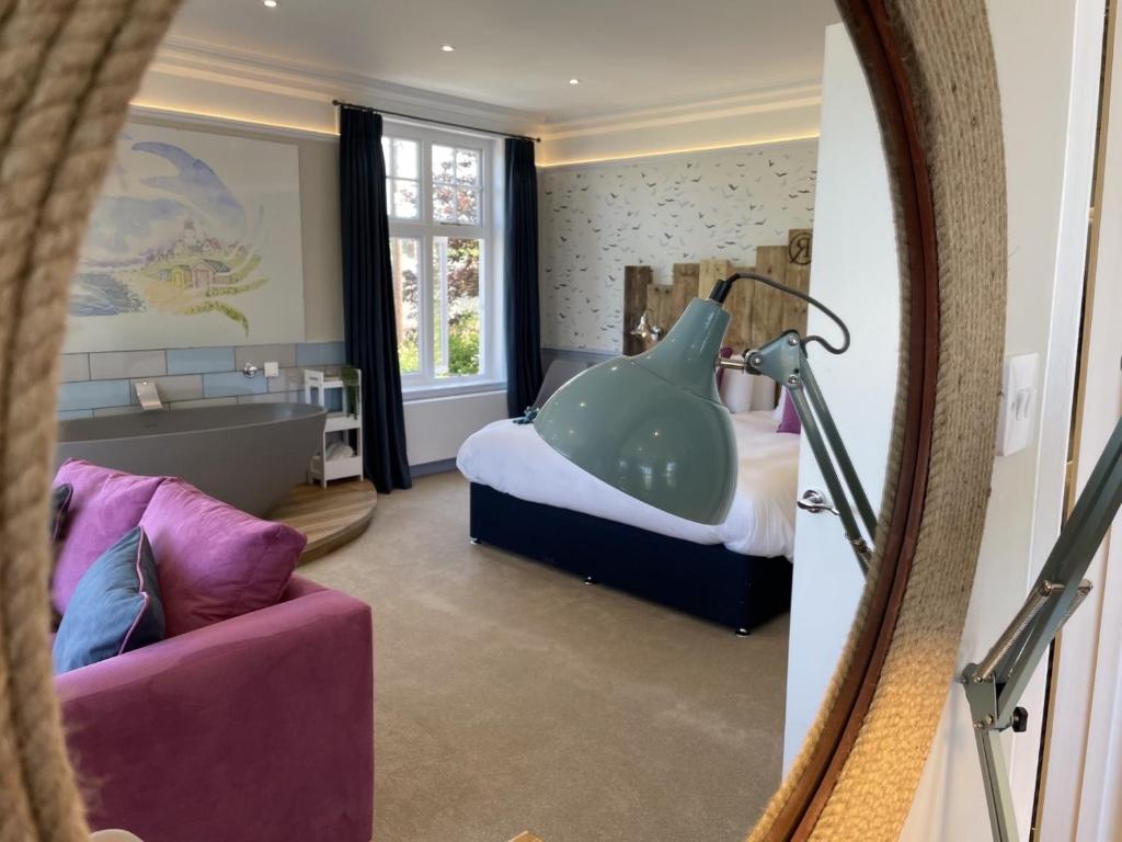 a bathroom with a bath tub in a bedroom at The Randolph Hotel in Southwold