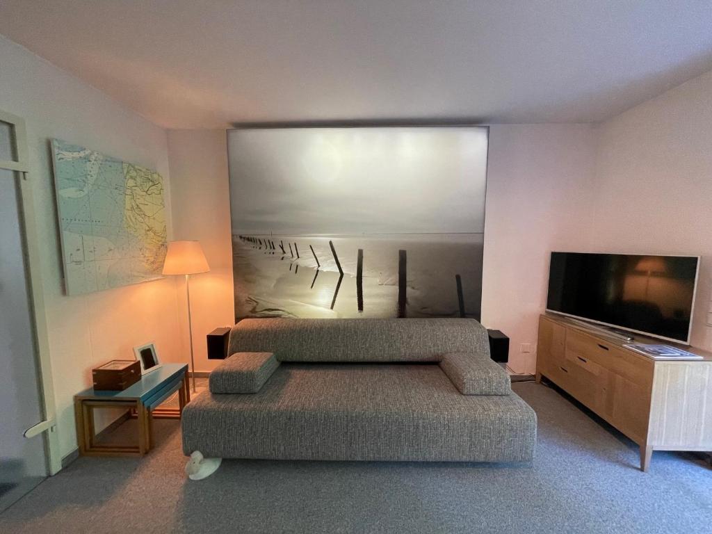 a living room with two beds and a flat screen tv at Ferienwohnung "Zum Böhler Leuchtturm" in Sankt Peter-Ording