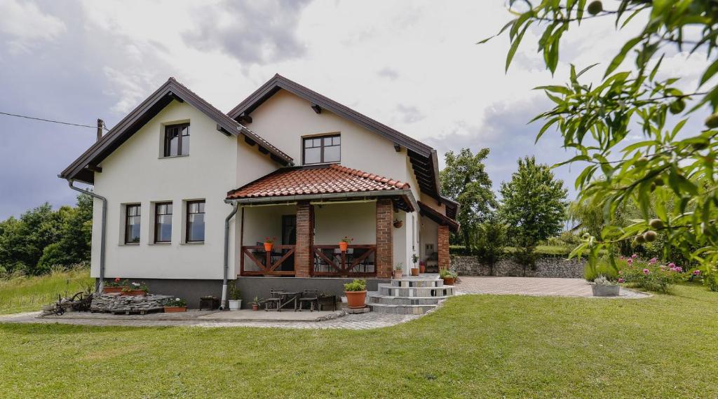 uma casa branca com um alpendre e um relvado em Kuća za odmor Sofija em Varaždinske Toplice