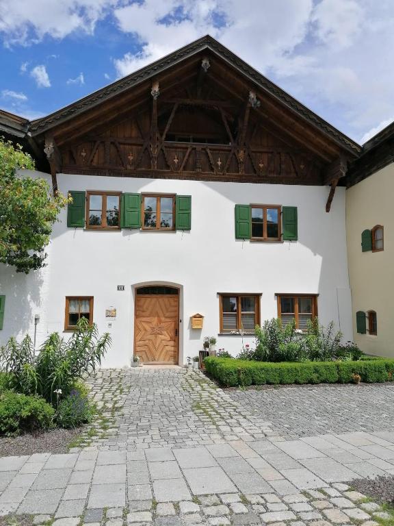 an exterior view of a white house with a wooden door at Ferienwohnung Bergluft in Mittenwald