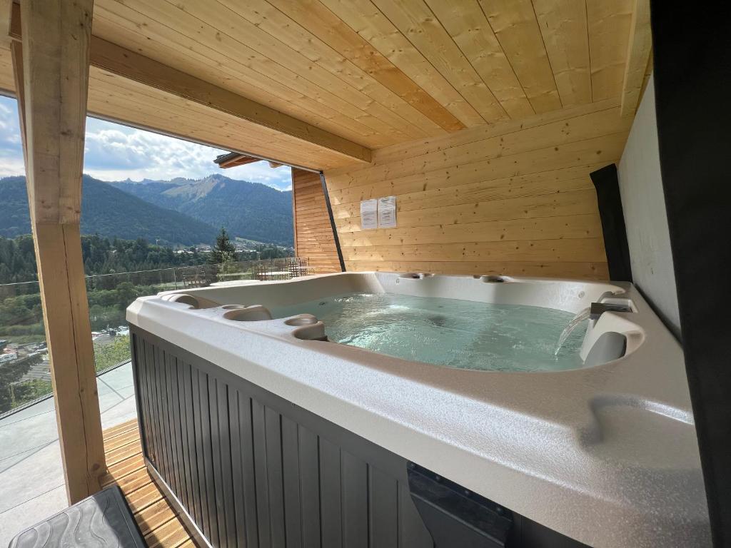 a jacuzzi tub on a balcony with a view at Les Trois Chaufatons - Chalets Boutiques in Montriond