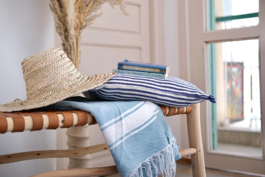 a straw hat sitting on top of a chair with a pillow at Riad Lauriers Blancs in Marrakesh