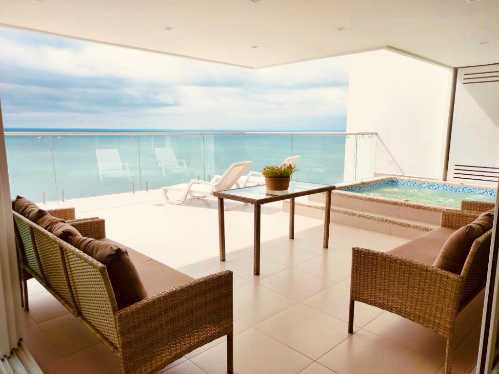 朵索巴的住宿－Departamentos frente al mar Resort Playa Azul，阳台配有桌子,享有海景。
