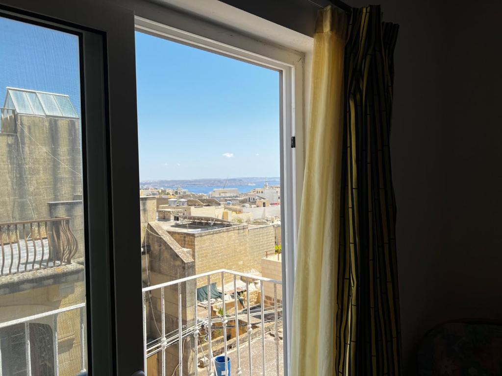 a window with a view of a city at All Nations Holiday Home in Għajnsielem