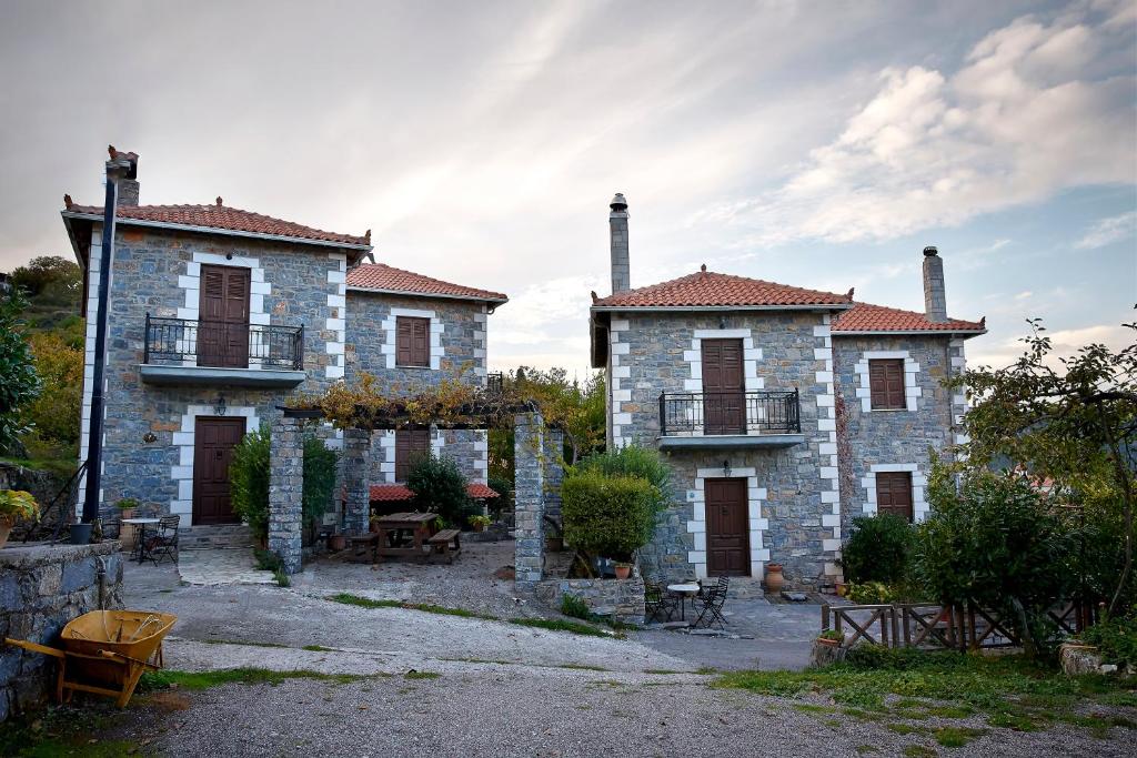 a large stone building with two chimneys on it at Malevos Traditional Houses in Áyios Pétros