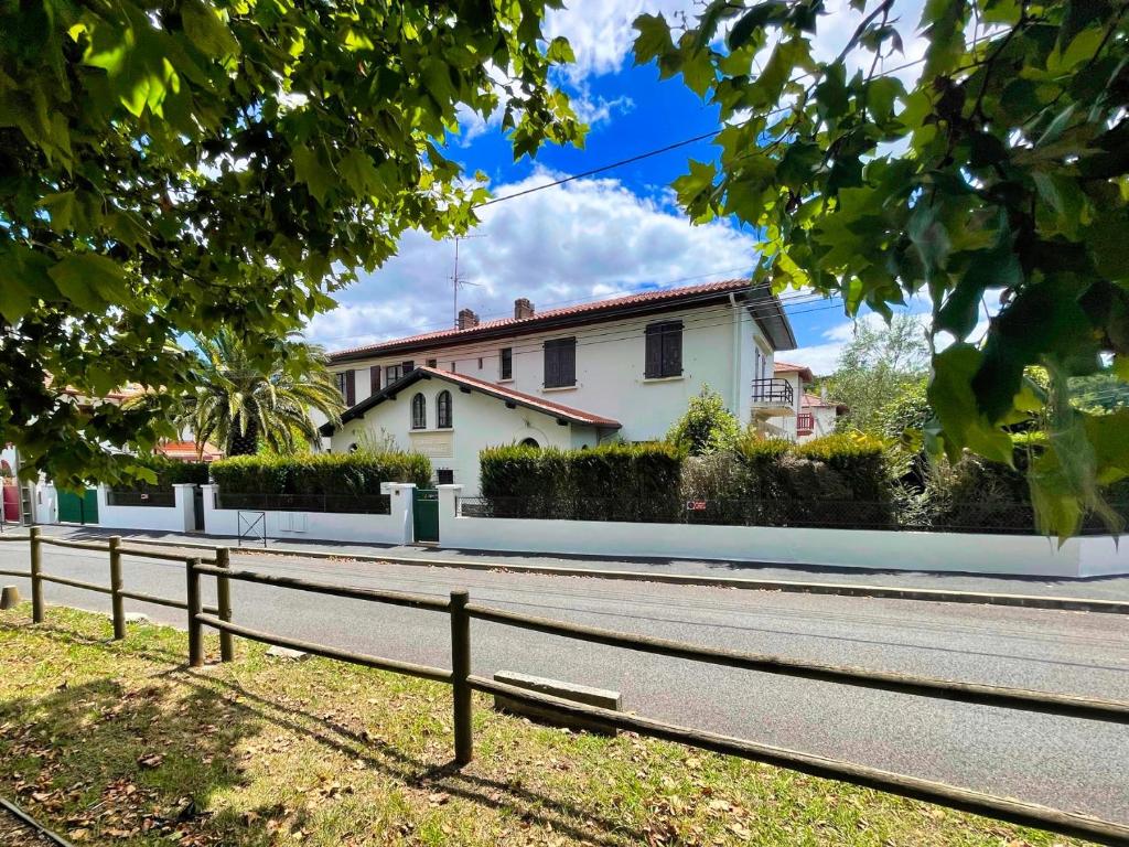 une maison blanche sur le côté d'une route dans l'établissement Biarritz-Anglet Appartement T3 en villa jumelle, à Anglet