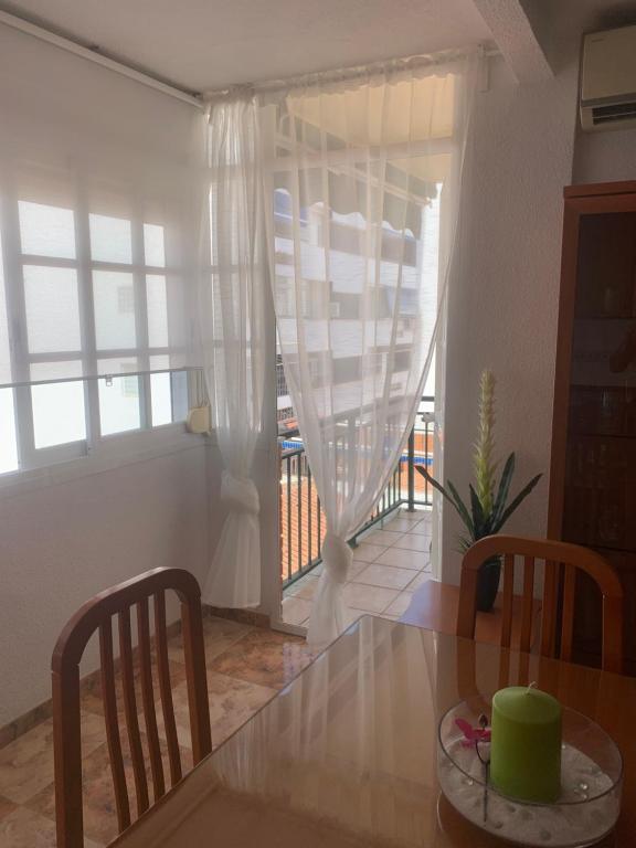 une salle à manger avec une table et des chaises et une fenêtre dans l'établissement Apartamento Centro, à Torre del Mar