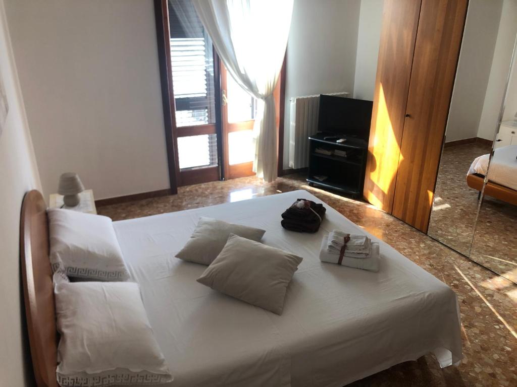 1 cama con sábanas blancas y almohadas en una habitación en CasAnna nel cuore del Salento Arnesano LE, en Arnesano