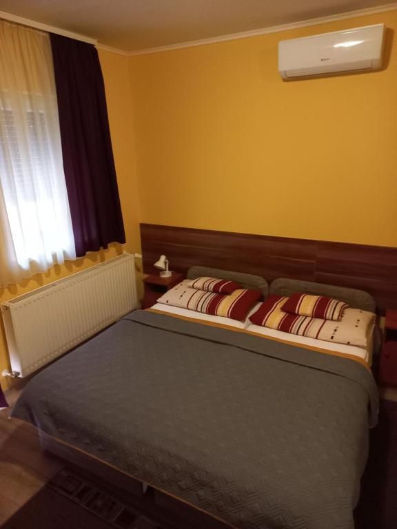 um quarto com uma cama e uma janela em Boglárka Vendégház em Mosonmagyaróvár